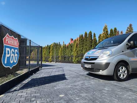 Brama wjazdowa z banerem Parking P66 i bus transferowy
